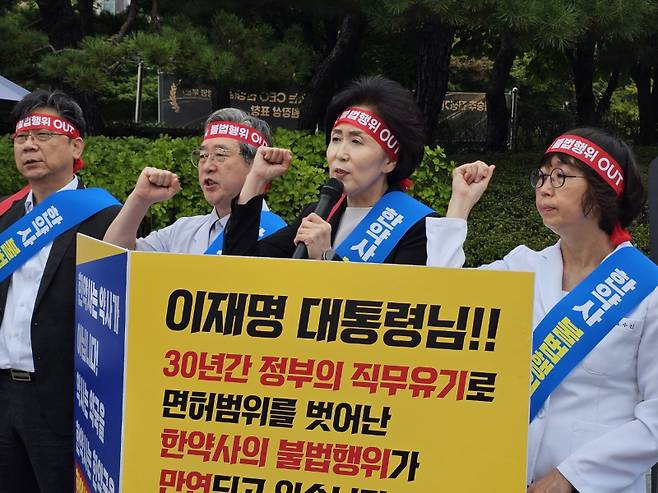 권영희 대한약사회장(가운데)이 18일 대통령실 앞에서 집회를 하고 있다. 이찬종 기자