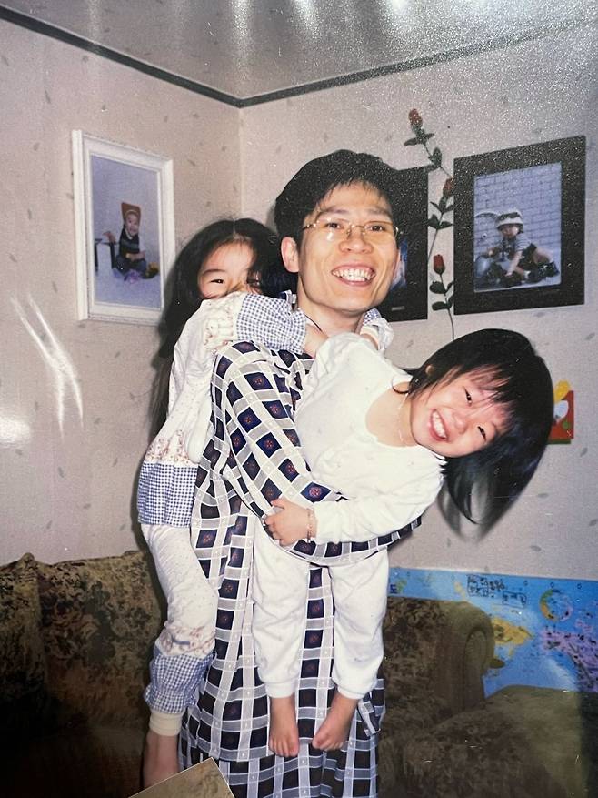 최 원장이 어린 두 딸을 안아주며 미소짓는 모습. 첫째 딸 보인씨는 이를 ‘대롱대롱 사진’이라고 부르며 “행복한 순간으로 기억한다”고 말했다. 최 원장 제공