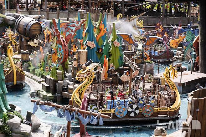 [올랜도( 미 플로리다주)=AP/뉴시스]올랜도 유니버설 리조트의  에픽 유니버스 테마 파크에 있는 "용 길들이기" 코너에서 사람들이 용 장식이 붙은 보트를 타며 즐기고 있다. 2025. 09.19.