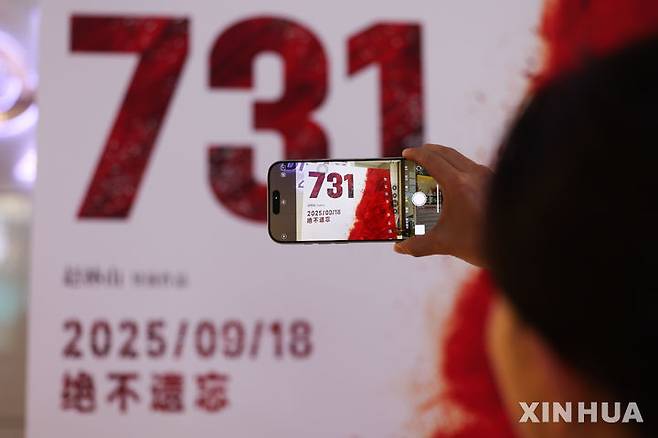 [스좌장=신화/뉴시스]중국 북부 허베이성 스자좡의 한 영화관에서 관객이 영화 731 포스터를 촬영하고 있다. 이 영화는 제2차 세계대전 당시 일본의 악명 높은 731부대의 만행을 다룬 작품으로, 지난 18일 중국 전역 극장에서 개봉했다. 2025.09.19.