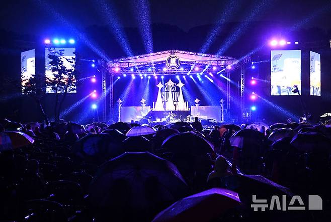[수원=뉴시스] 김종택 기자 = '2025 수원재즈페스티벌'이 열린 19일 오후 경기 수원시 광교호수공원 재미난 밭에서 잔디광장을 가득 메운 시민들이 흥겨운 재즈 선율을 즐기고 있다. 2025.09.19. jtk@newsis.com