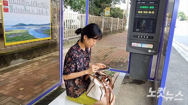 버스정류장에서 버스 도착 시간을 애플리케이션으로 확인하는 민혜씨. 박사라 기자