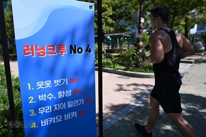 여러 명이 함께 달리는 ‘러닝크루’의 일부 행동이 논란이 된 가운데 18일 서울 여의도공원에 러닝크루의 금지 사항을 알리는 안내문이 설치돼 있다. 홍윤기 기자