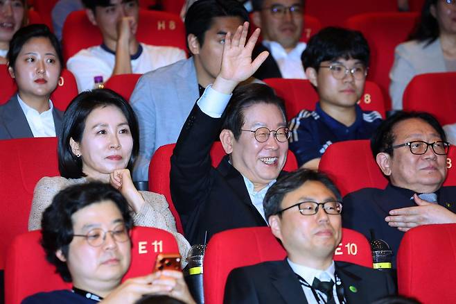 이재명 대통령이 20일 부산 해운대구 영화의전당에서 부산국제영화제 공식상영작 ‘극장의 시간들’을 관람한 뒤 감독과 배우에게 질문하기 위해 손을 들고 있다. (대통령실통신사진기자단) 2025.09.20. 뉴시스
