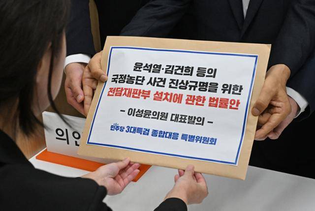이성윤 의원 등 더불어민주당 3대특검 종합대응특위 위원들이 18일 오전 서울 여의도 국회 의안과에서 내란국정농단 전담재판부 설치법을 제출하고 있다. 사진공동취재단