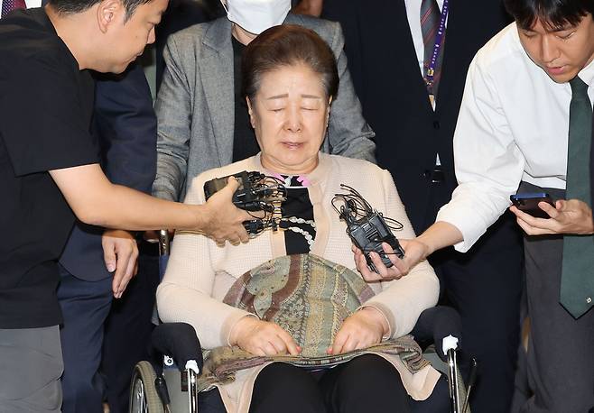 한학자 통일교 총재가 17일 서울 종로구 KT광화문빌딩에 있는 민중기 특별검사팀에서 조사를 받은 뒤 휠체어를 타고 귀가하면서 취재진에 둘러싸여 질문을 받고 있다. 연합뉴스