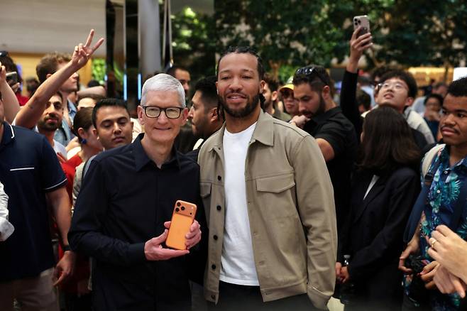 팀 쿡 애플 최고경영자(CEO)가 19일(현지시간) 미국 뉴욕 맨해튼 애플스토어에서 아이폰 17시리즈 출시를 기념해 NBA 뉴욕 닉스 소속 제일런 브런슨과 함께 기념사진을 촬영하고 있다. /로이터=뉴스1