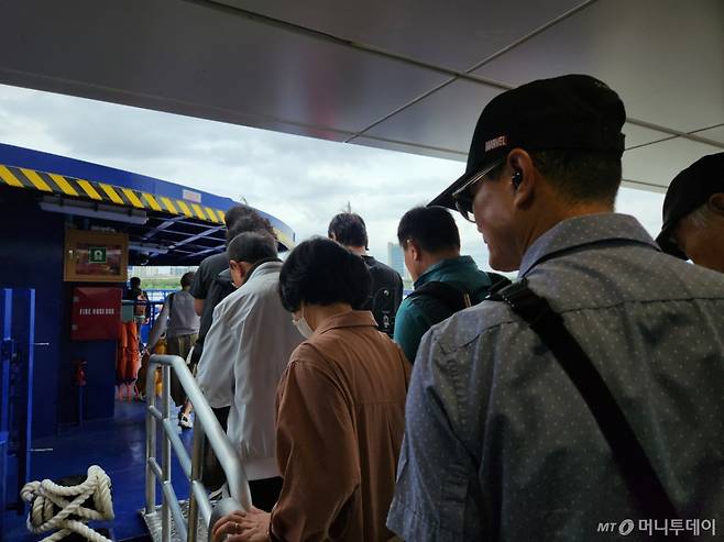 19일 오전 한강버스에 탑승하고 있는 사람들. 선박에 오르면 안전요원이 '안에 자리가 많으니 천천히 들어오라'며 승객들을 안내했다. /사진=김서현 기자.