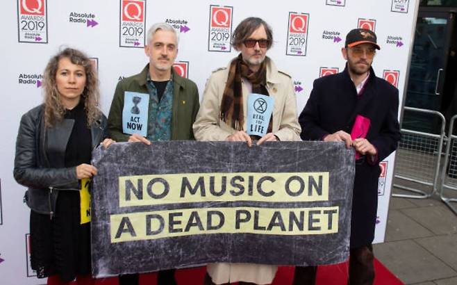 지난 2019년 Q 어워드에 참석한 펄프(Pulp)의 자비스 코커가 “죽은 행성 위에 음악은 없다”(NO MUSIC ON A DEAD PLANET)라는 슬로건이 적힌 배너를 들고 기후 변화의 심각성을 알리고 있다. [게티이미지/Photo by Jo Hale]