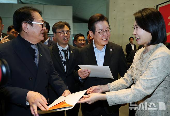 [부산=뉴시스] 최동준 기자 = 이재명 대통령과 김혜경 여사가 20일 부산 해운대구 영화의전당에서 부산국제영화제 공식상영작 '극장의 시간들' 관람에 앞서 기념우표를 전달받고 있다. (대통령실통신사진기자단) 2025.09.20. photocdj@newsis.com