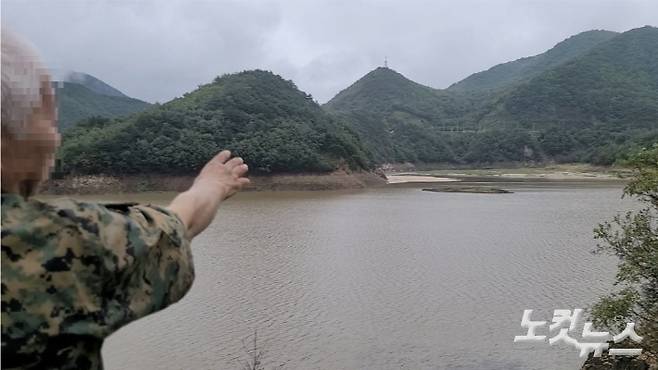오봉저수지 안에 섬으로 불리는 말구리재를 가리키고 잇는 한 시민. 전영래 기자