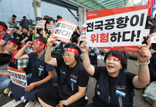 전국공항노동자연대가 19일 인천 영종도 인천국제공항 제2여객터미널에서 연 총파업 대회에서 참가자들이 손팻말을 들고 있다. 전국공항노동자연대는 이날 경고 파업을 진행한 후 추석 연휴 전 무기한 총파업을 진행할 것이라고 예고했다. 연합뉴스
