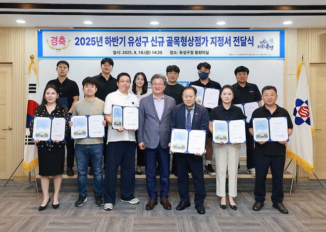 19일 정용래 유성구청장이 하반기에 신규 지정된 13개 구역의 신규 골목형상점가에 지정서를 전달하고 기념촬영을 하고 있다. (사진= 대전 유성구)