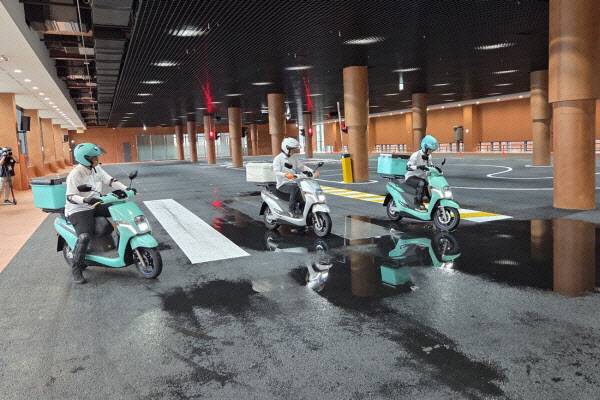 실내 도로에 설치된 횡단보도와 신호등 앞에서 주행 훈련을 선보이고 있는 강사들. 날씨와 무관하게 실제 상황을 재현할 수 있다. (사진=한전진 기자)