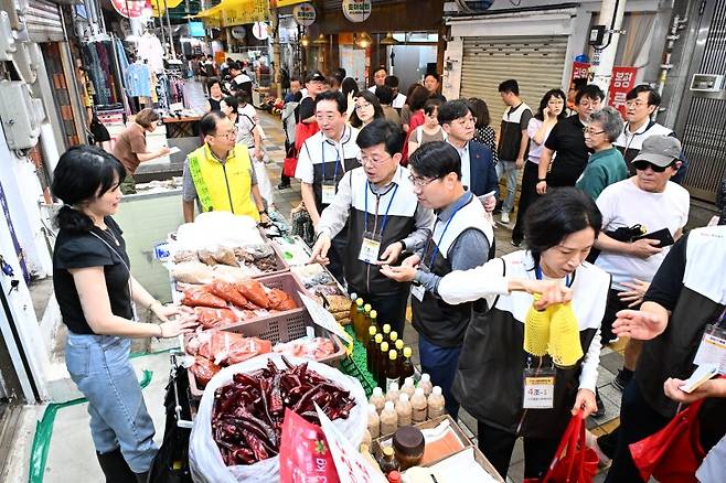 지난 20일 부산, 울산, 경남 일대 전통시장에서 'BNK 사회공헌의 날' 행사가 열린 가운데 빈대인 BNK금융그룹 회장(가운데)과 임직원들이 부산 해운대구 반송큰시장에서 복지관에 전할 생필품을 둘러보고 있다.