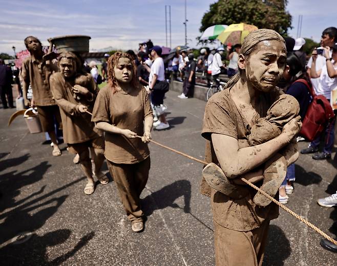 필리핀 시위대가 21일 진흙으로 몸을 뒤덮은 채 홍수 기반시설 프로젝트 비리 스캔들에 항의하는 시위를 열고 있다. EPA연합뉴스