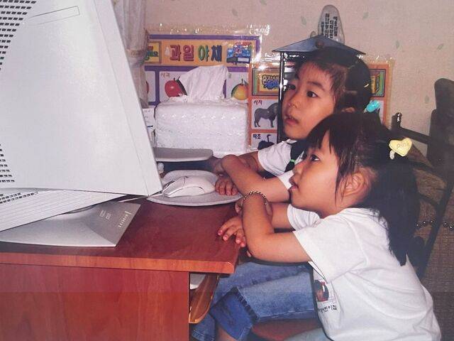 어린 시절 두 자매가 아빠의 컴퓨터 모니터를 보며 큐티하는 모습.  최 원장 제공