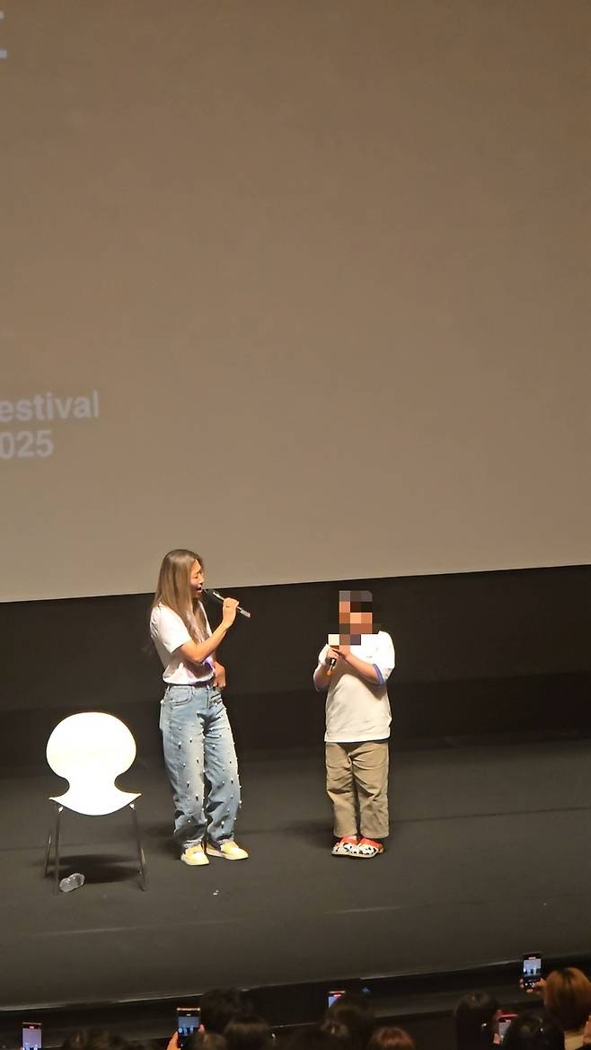 매기 강 감독(왼쪽)이 ‘케이팝 데몬 헌터스’ 싱어롱 상영을 찾은 어린이 관객과 함께 영화 OST인 ‘테이크 다운’을 함께 부르고 있다. 손미정 기자