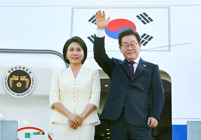 이재명 대통령과 김혜경 여사가 일본·미국 방문을 위해 지난 8월 23일 성남 서울공항을 출발하며 공군 1호기에 올라 인사하고 있다. [연합]