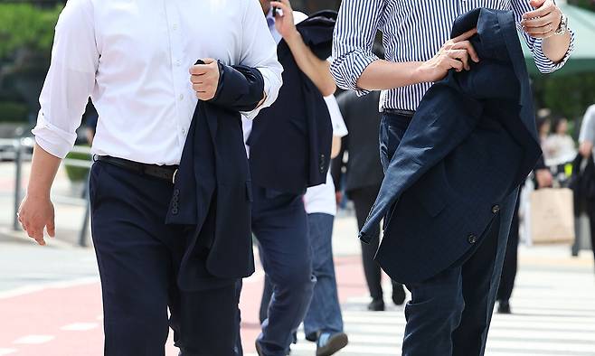 서울 남대문시장 인근에서 직장인들이 외투를 벗은 채 걸어가고 있다. 연합뉴스