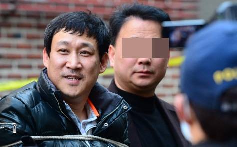김상훈이 2015년 1월 현장검증 때 가족을 잃은 유족들이 울부짖자 웃고 있다. 연합뉴스
