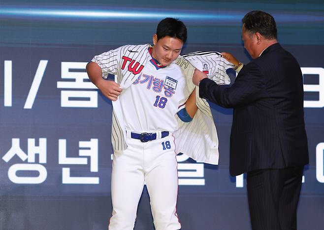 1라운드 8순위 지명을 받은 경기항공고 양우진이 LG 유니폼을 입고 있다. 오른쪽은 LG 차명석 단장. 연합뉴스