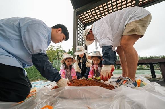 지난 20일 어플라이드 머티어리얼즈 코리아 임직원과 그 가족 자원봉사단이 경기 화성시 동탄 신리천에서 EM 흙공을 만들고 있다. [사진=어플라이드 머티어리얼즈 코리아]