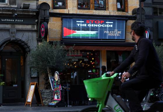 21일(현지시간) 영국 런던 팔레스타인 하우스의 전광판에 집단 학살을 멈춰라는 문구가 등장했다. 로이터=연합뉴스