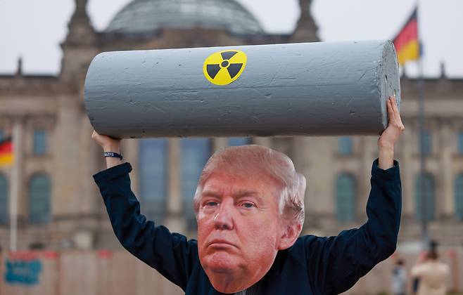 독일 베를린에서 지난 18일(현지시간) 평화 활동가들이 도널드 트럼프 미국 대통령의 모형을 쓰고 그를 풍자하고 있다. [EPA]