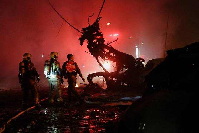 15일(현지시간) 이스라엘 하이파에서 이란에서 이스라엘로 미사일이 발사된 후 비상 요원이 작전을 수행하고 있다. [로이터]