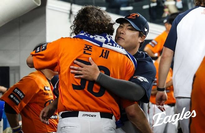 한화 이글스 코디 폰세가 13일 대전 한화생명볼파크에서 열린 2025 KBO리그 정규시즌 키움 히어로즈와의 홈 경기에서 6이닝 무실점으로 개막 17연승을 달성하고 류현진과 포옹하고 있다. 한화 이글스 제공