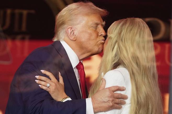 도널드 트럼프 미국 대통령이 2025년 9월 21일(현지시간) 애리조나주 글렌데일의 스테이트팜 스타디움에서 열린 보수 활동가 찰리 커크 추모식에서 그의 부인 에리카 커크에게 입맞춤하고 있다.  AP뉴시스