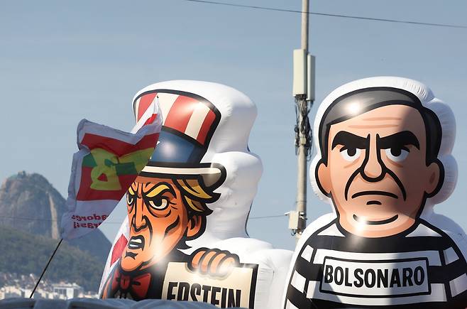 21일 브라질 리우 데 자네이루의 코파카바나 해변에 등장한 도널드 트럼프 미 대통령(왼쪽)과 자이르 보우소나루 전 브라질 대통령 모형. /로이터 연합뉴스