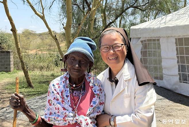 정춘실 케냐 성 데레사 진료소장(오른쪽)이 진료소를 방문한 환자를 부축하며 활짝 웃고 있다.  아산사회복지재단 제공