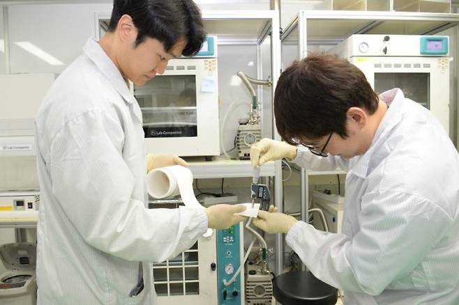 ETRI 연구팀이 롤 형태로 제작된 대면적 고체전해질막께를 정밀 측정하는 모습. ETRI 제공.
