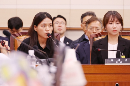 22일 국회 법제사법위원회에서 열린 ‘건진법사 관봉권 띠지’ 분실 관련 검찰개혁 입법청문회에서 김정민 수사관(왼쪽)이 더불어민주당 전현희 의원 질의에 답하고 있다.   [연합뉴스]