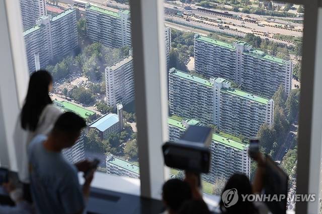 시민들이 서울 아파트 밀집 지역을 바라보고 있다. [연합뉴스]