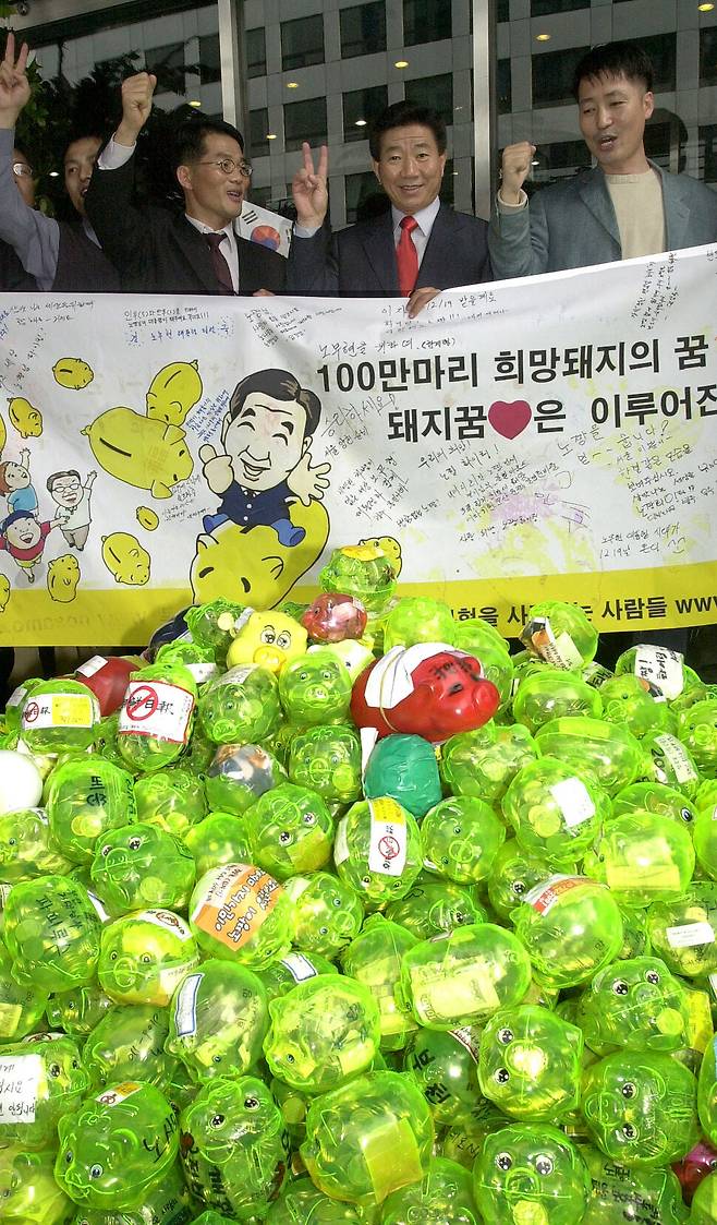 2002년 9월30일 서울 여의도 새천년민주당 당사에서 열린 대통령선거 중앙선거대책위원회 출범식에서 노무현 후보가 노사모(노무현을 사랑하는 사람들의 모임)와 함께 ‘희망의 돼지저금통 전달식’을 하고 있다. 한겨레 김경호 선임기자 jijae@hani.co.kr