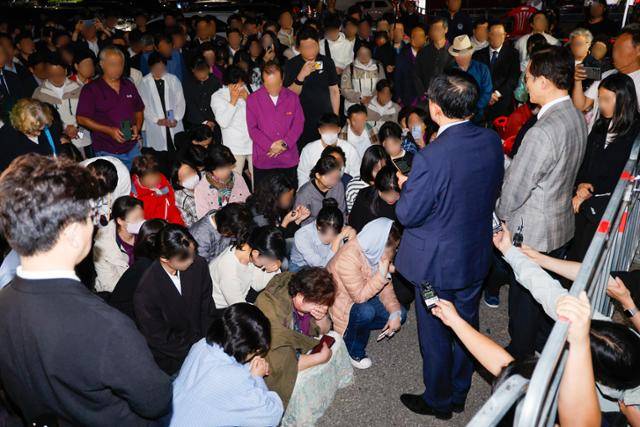 한학자 통일교 총재의 구속영장이 발부된 23일 새벽 경기 의왕시 서울구치소 앞에서 한 총재의 영장 기각 소식을 기다리던 신도들이 통일교 측 입장 발표를 듣고 있다. 뉴스1