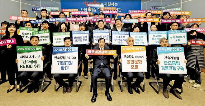 충남테크노파크는 탄소중립을 위한 기업 지원 및 실천문화 조성 등 다양한 사업을 추진하고 있다. 서규석 원장(첫 번째 줄 가운데)과 직원들이 올해 3월 열린 선포식에서 RE100 실현 문구가 담긴 손팻말을 들고 기념사진을 찍고 있다. /충남TP 제공