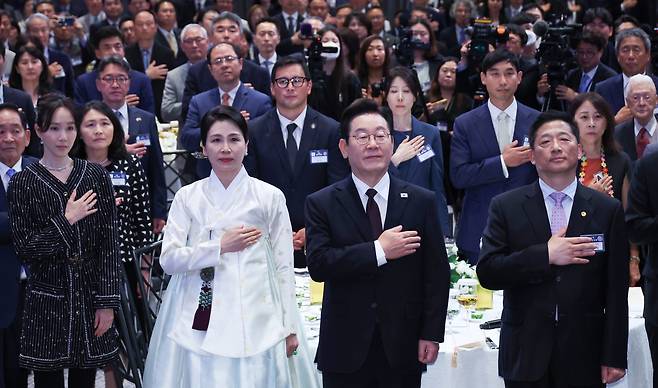 유엔총회 참석차 미국을 방문한 이재명 대통령이 22일(현지시간) 뉴욕의 한 호텔에서 열린 동포간담회에서 참석자들과 함께 국기에 경례하고 있다. [연합]