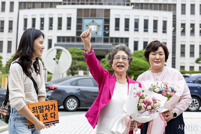 9월10일 최말자씨(가운데)가 재심에서 무죄선고를 받고 부산지방법원 앞에서 손을 들고 있다. 최씨 왼쪽이 최선혜 한국여성의전화 사무처장, 오른쪽은 대학 동기인 윤향희씨다. ⓒ시사IN 박미소