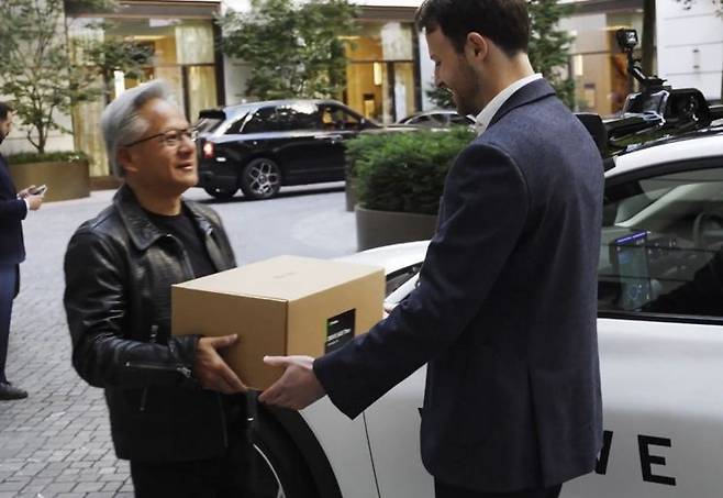 웨이브 창업자 알렉스 켄달에 차세대 AI 컴퓨터를 전달하는 젠슨 황 엔비디아 최고경영자(CEO). 엑스(X) 캡처