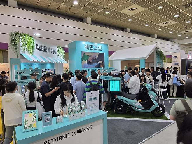 방문객들이 24일 서울 강남구 코엑스에서 열린 2025 대한민국 ESG 친환경대전 배달의민족 부스를 찾아 설명을 듣고 있다. 부스를 주관한 우아한형제들은 이날 다회용 배달용기 서비스, 전기 이륜차 생태계 구축 등 친환경 사업을 소개하고 방문객들에게 쿠폰을 선물했다. 차승윤 기자&nbsp;