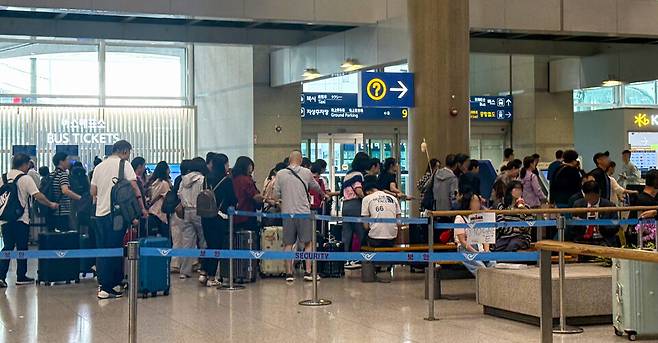▲ 중국 단체관광객 무비자 제도 시행을 앞둔 25일 인천국제공항 입국장이 단체 여행객으로 붐비는 가운데, 가이드가 깃발을 들고 일행을 인솔하고 있다.
