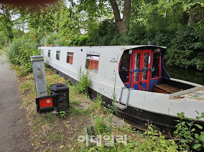 옥스포드 중심가를 흐르는 운하에 정박해있는 배 모습. 운항용 배가 아닌 주거용 배로, 전기를 공급할 수 있는 콘센트 포스트가 옆에 있다.(사진=안치영 기자)