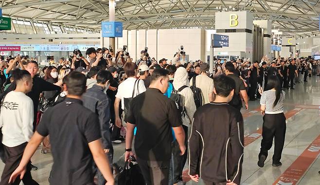 지난 6일 오전 인천국제공항 출국장에서 아이돌 그룹 라이즈(RIIZE)가 경호원에 둘러싸여 출국장으로 이동하고 있다. 이를 보기 위해 몰려든 팬들과 홈마들이 사설경호업체가 만든 인간띠 뒤에서 몸싸움을 벌였다. /남강호 기자