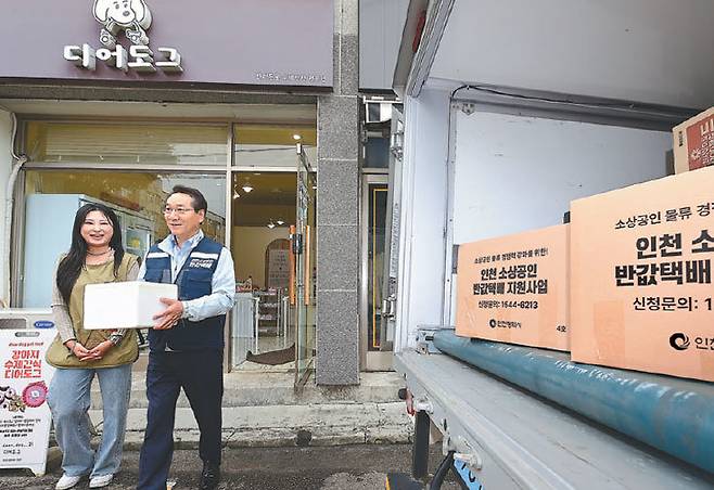 올해 6월 26일 유정복 인천시장(오른쪽)이 부평구의 한 상점을 방문해 소상공인과 함께 천원택배로 보낼 배송 물품 차량에 싣고 있다. 인천시 제공