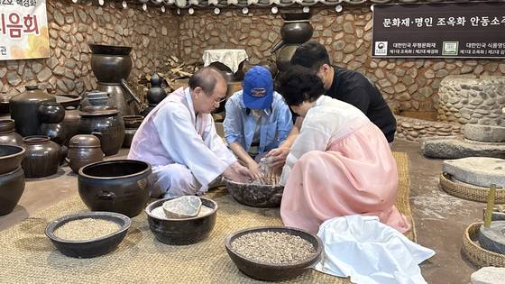 Visitors make Andong soju with Kim Yeon-bak and his wife Bae Kyung-hwa at the Andong Soju Museum.[WOO JI-WON]