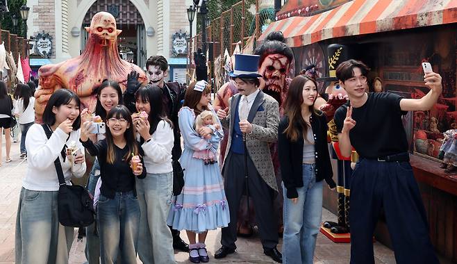 25일 오전 서울 송파구 롯데월드 어드벤처 매직아일랜드를 찾은 학생들이 롯데월드 호러 판타지 가을 시즌 축제 ‘스트리트 호러쇼: 더 마리오네트’ 연기자들과 함께 기념촬영을 하고 있다. 임세준 기자